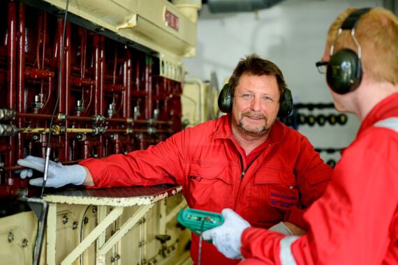 Ausbilder erklärt Azubi Teile des Schiffsmotors