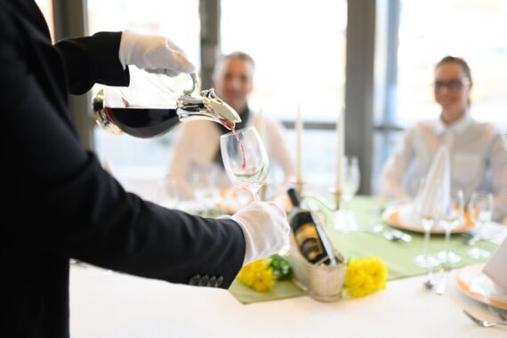 ein Glas Wein wird eingeschenkt