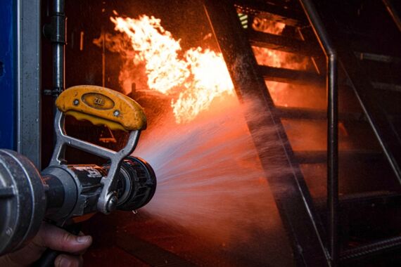 Feuer wird mit einem Schlauch gelöscht